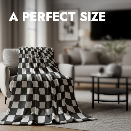 Black and white checkered fleece blanket draped over a chair in a living room setting with text 'A PERFECT SIZE'.