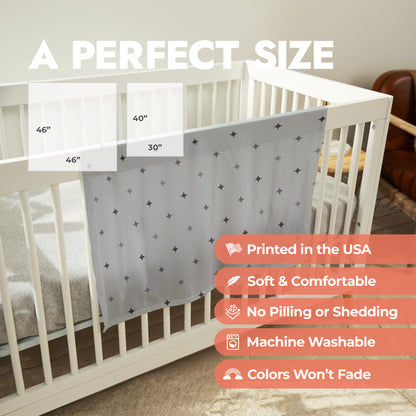 Star patterned baby swaddle draped over a crib with product size chart and product features list.