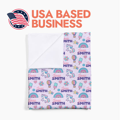 Folded personalized baby swaddle with unicorns and ice cream printed on it with header text 'USA based business'