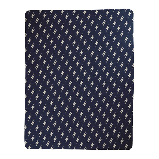 Navy background with white lightning bolt pattern printed on a sherpa fleece backed blanket.