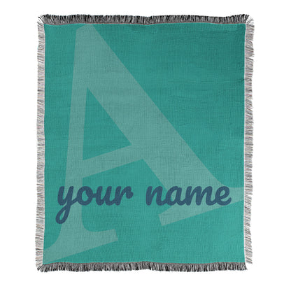 Teal blanket with a large letter 'A' and space for 'your name'