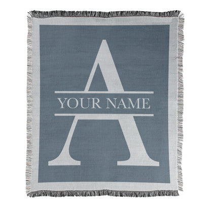 Blanket with a large letter 'A' and example text displaying 'Your Name' on a blue blanket with decorative fringe edges