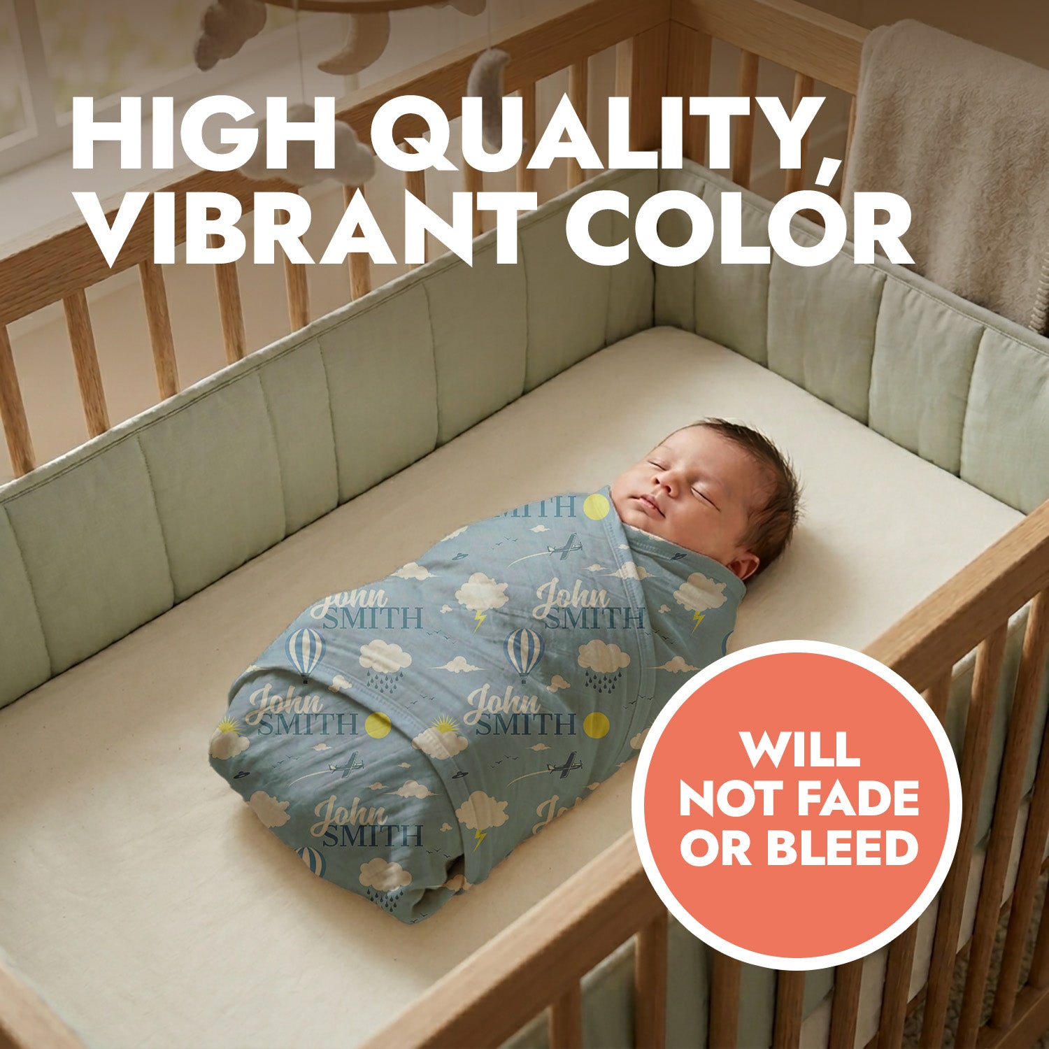 Newborn baby swaddled in a blue swaddle with 'John Smith' repeated with clouds & lightning, lying in a crib. Text 'High Quality, Vibrant Color' and 'Will Not Fade or Bleed' are displayed.