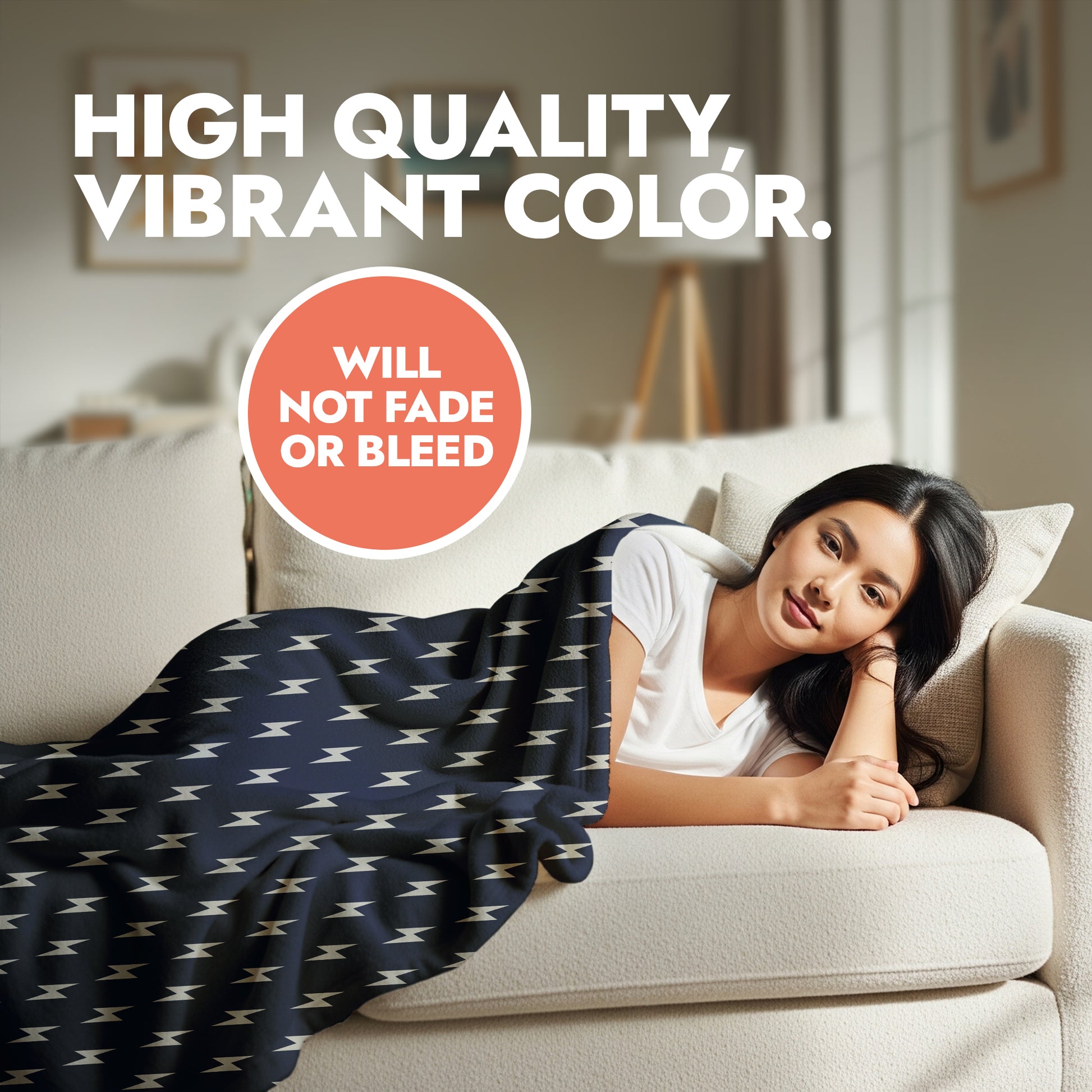 Woman lying on a couch with a navy blanket featuring white lightning bolt patterns, in a living room setting.